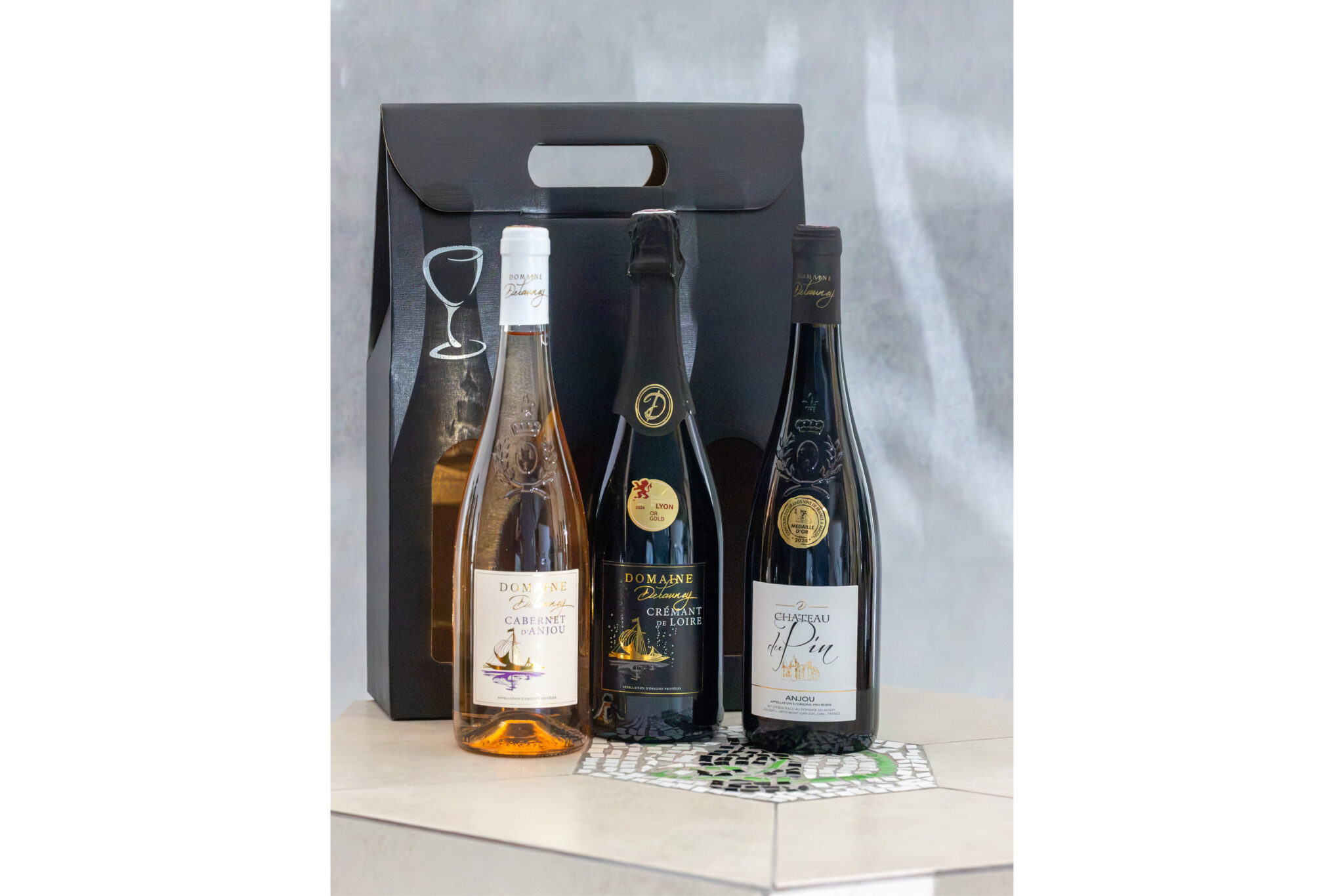 Trois bouteilles de vin avec emballage noir.